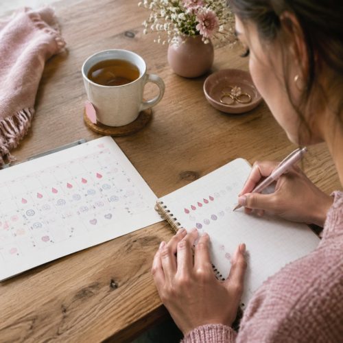 mulher anotando os sintomas do ciclo menstrual em um diário para o diagnóstico do TDPM